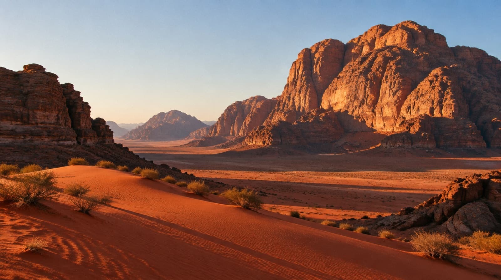 Red dunes and sandstone mountains in Wadi Rum at golden hour