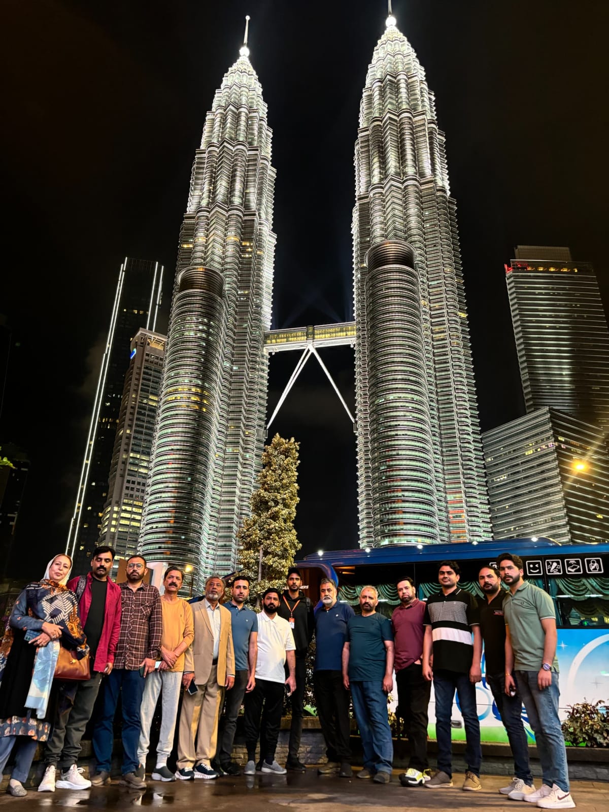 An IBEX group photographed at night beneath the lit Petronas Twin Towers in Kuala Lumpur